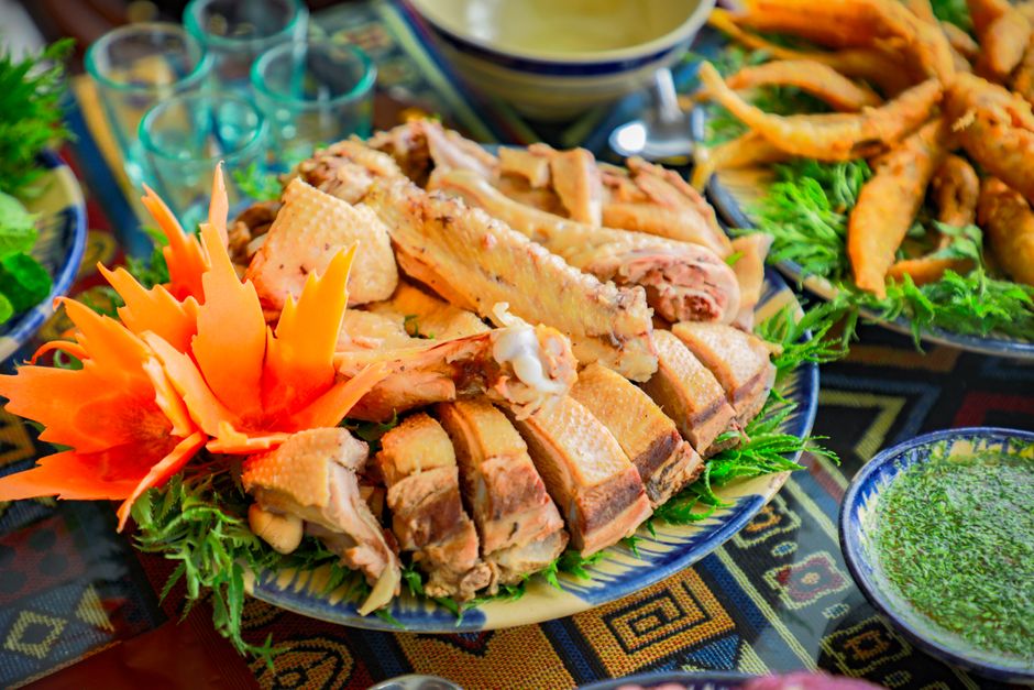 Close-up of a delectable roast chicken dish with vibrant carrot flower garnish. Perfect for dining promotions.