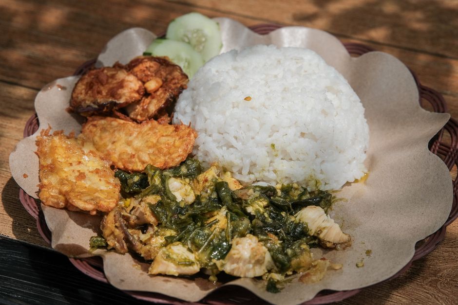 Plate of Indonesian rice with fried chicken, tempeh, and sambal, showcasing local culinary culture. 