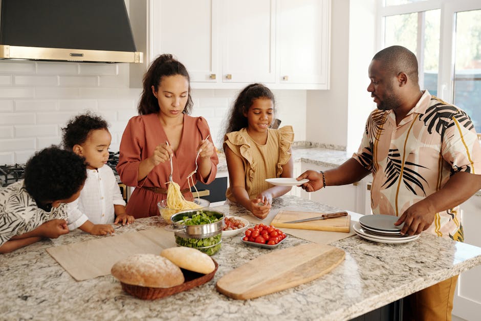 A diverse family preparing a meal together in a bright, modern kitchen setting.