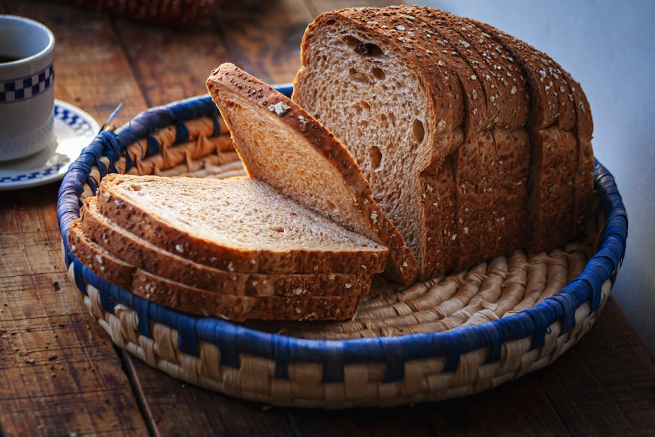Freshly sliced whole wheat bread in a wicker basket set on a rustic wooden table.
